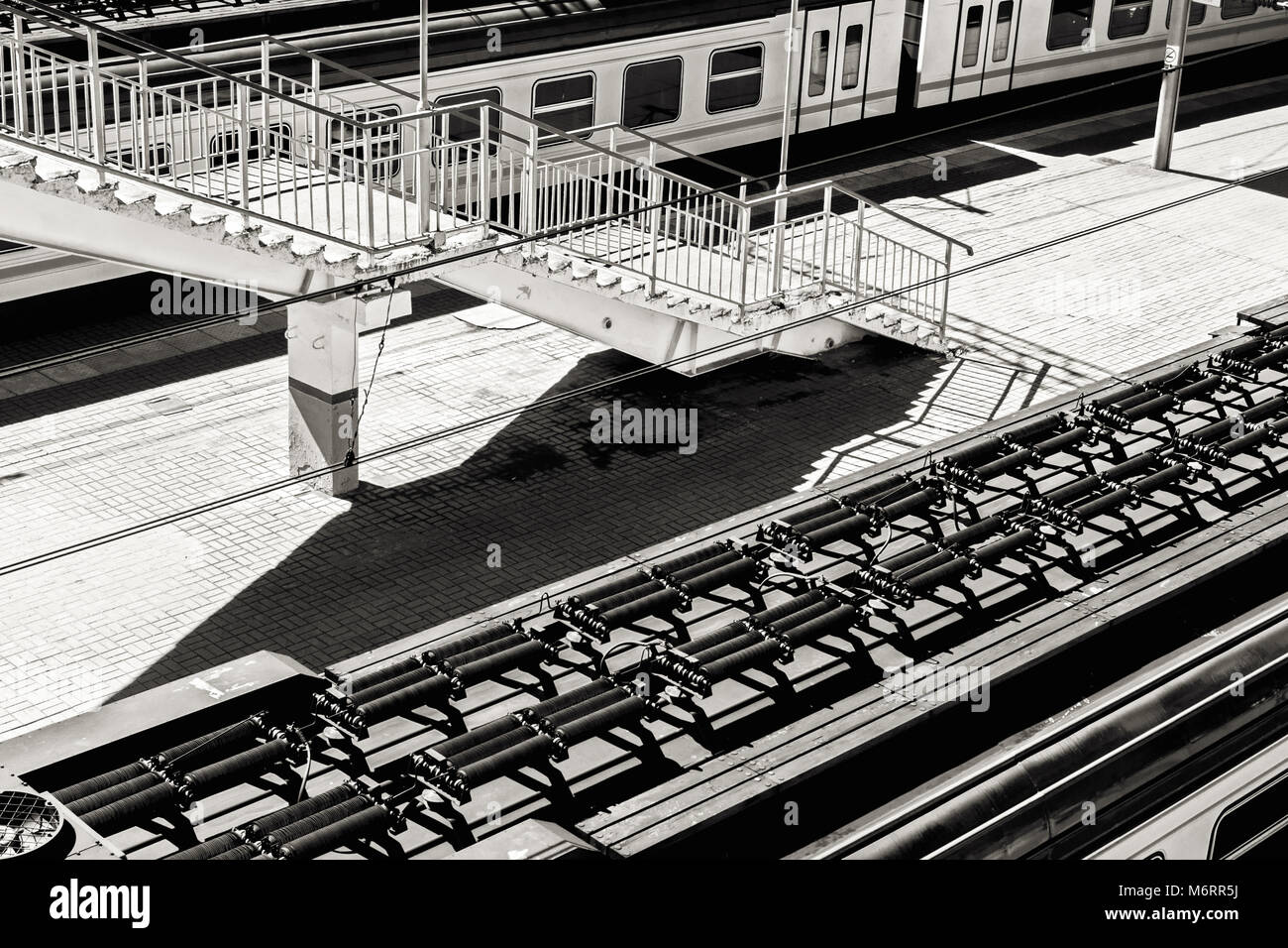 Züge und Treppe auf der Plattform die Ansicht von oben am sonnigen Sommertag in Schwarz und Weiß Stockfoto