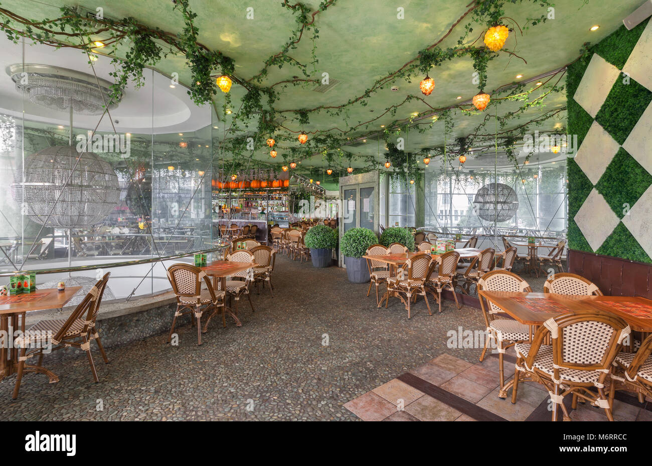 Moskau - Juli 2014: Chain Home Cooking Restaurant "GRABLI". Der Innenraum des Konzept der Gartenkunst Stil. Künstliche Reben an der Decke Stockfoto
