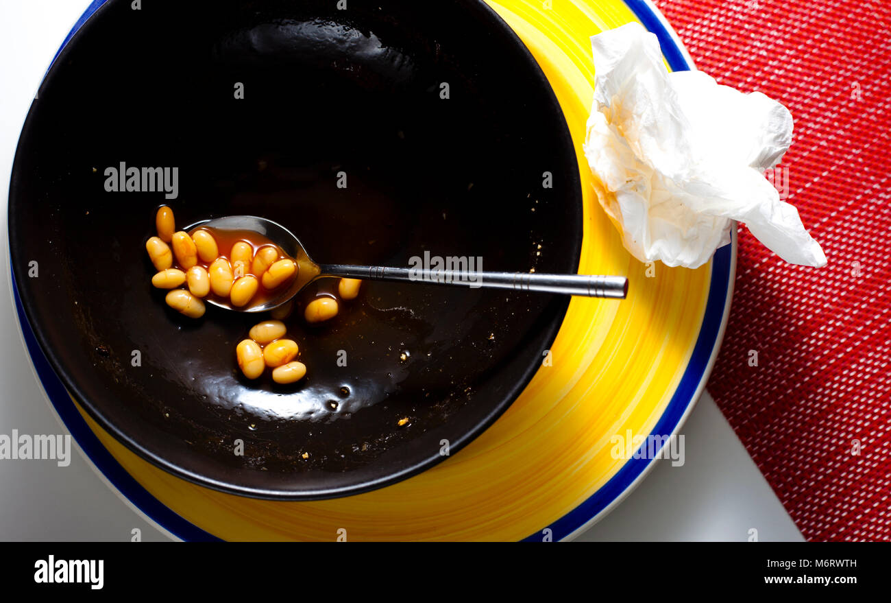 Ein fast leerer Schale Organic Baked Beans mit gebrauchten Serviette auf Seite Stockfoto