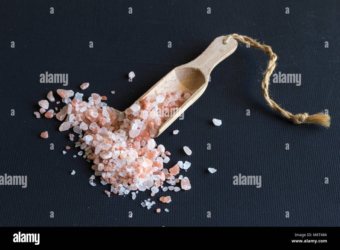 Himalaya Steinsalz- und Holz- Schaufel schließen bis auf schwarzem Hintergrund im Landhausstil Stockfoto