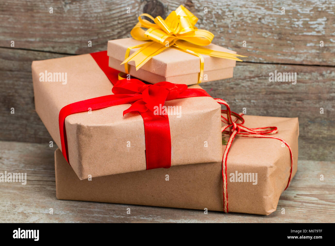 Geschenkboxen mit Kraftpapier auf hölzernen Hintergrund gewickelt, Ansicht von oben. Stockfoto