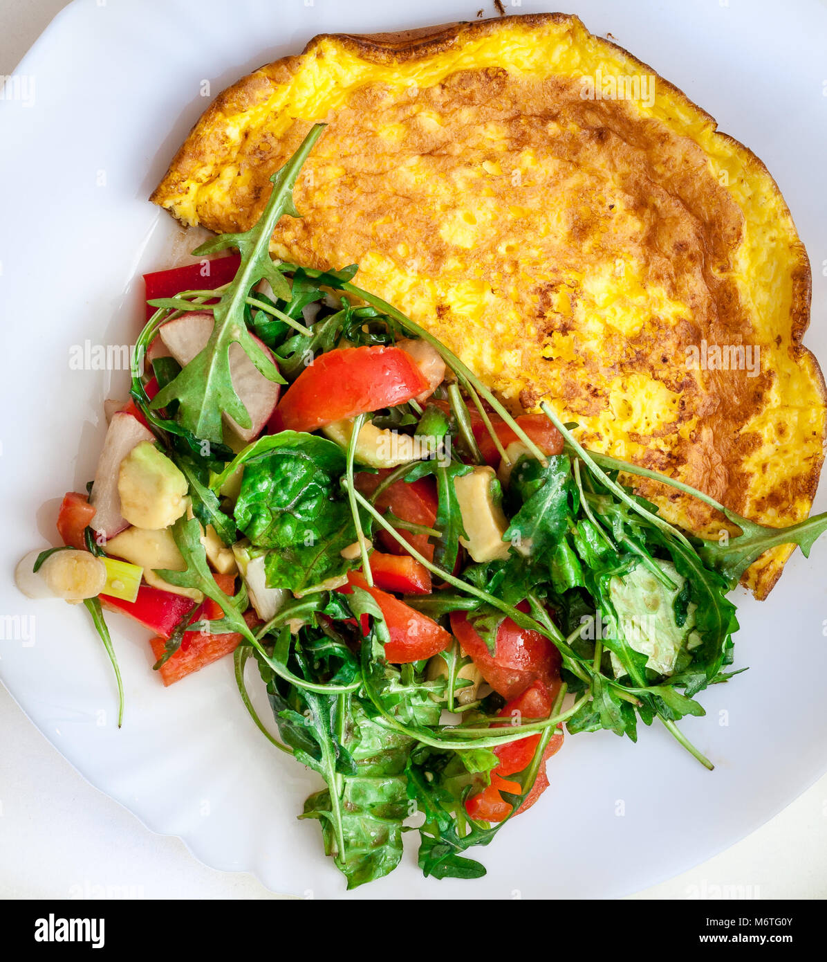 Hausgemachte Omelett mit Käse, Tomaten und Rucola Salat. Frühstück, morgen. Stockfoto