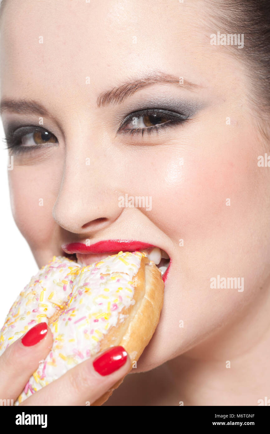 Frau beißen in Donut Stockfoto