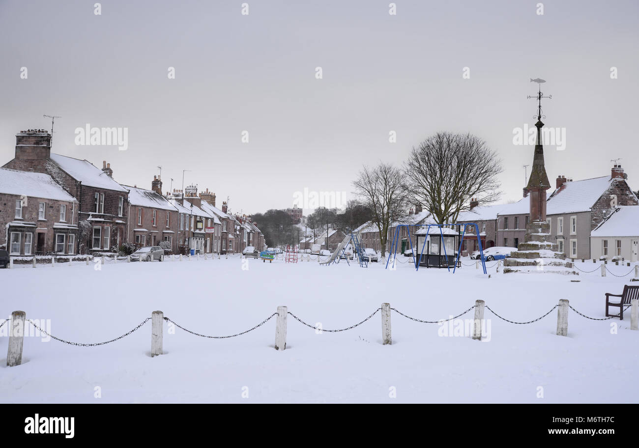 Schnee an norham Village Green nach Osten in Richtung der normannischen Burg geht zurück bis 1121 Stockfoto