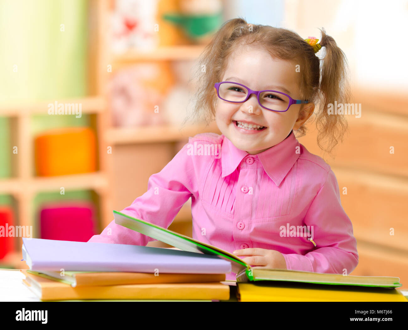 Kind in Brillen oder Brillen, Bücher zu lesen, in ihrem Zimmer Stockfoto
