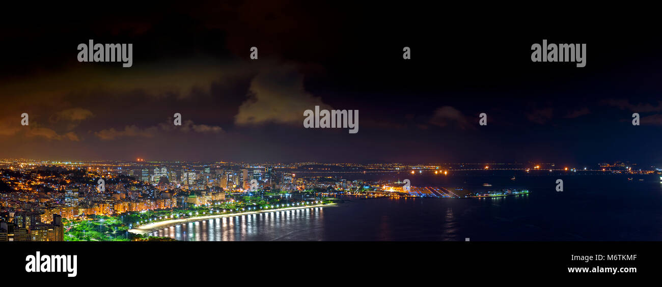 Panorama von Rio de Janeiro von oben bei Nacht mit seinen Lichtern, Hügel, Straßen, Rio-Nitreoi Gaunabara bucht, Brücke und Santos Dumont Airport Stockfoto