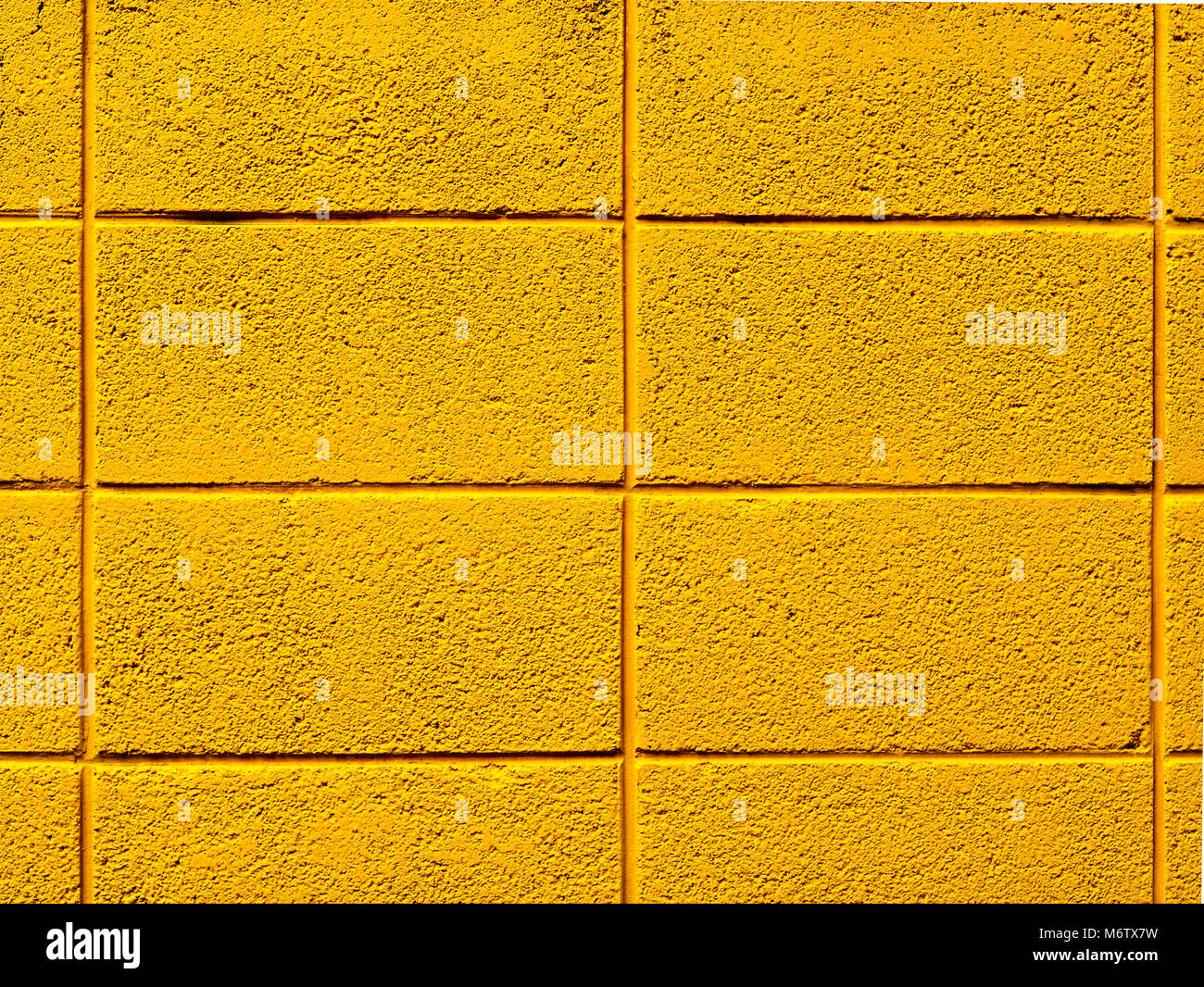 Leuchtend gelb lackierten cinder Block Wand Hintergrund Foto. Stockfoto