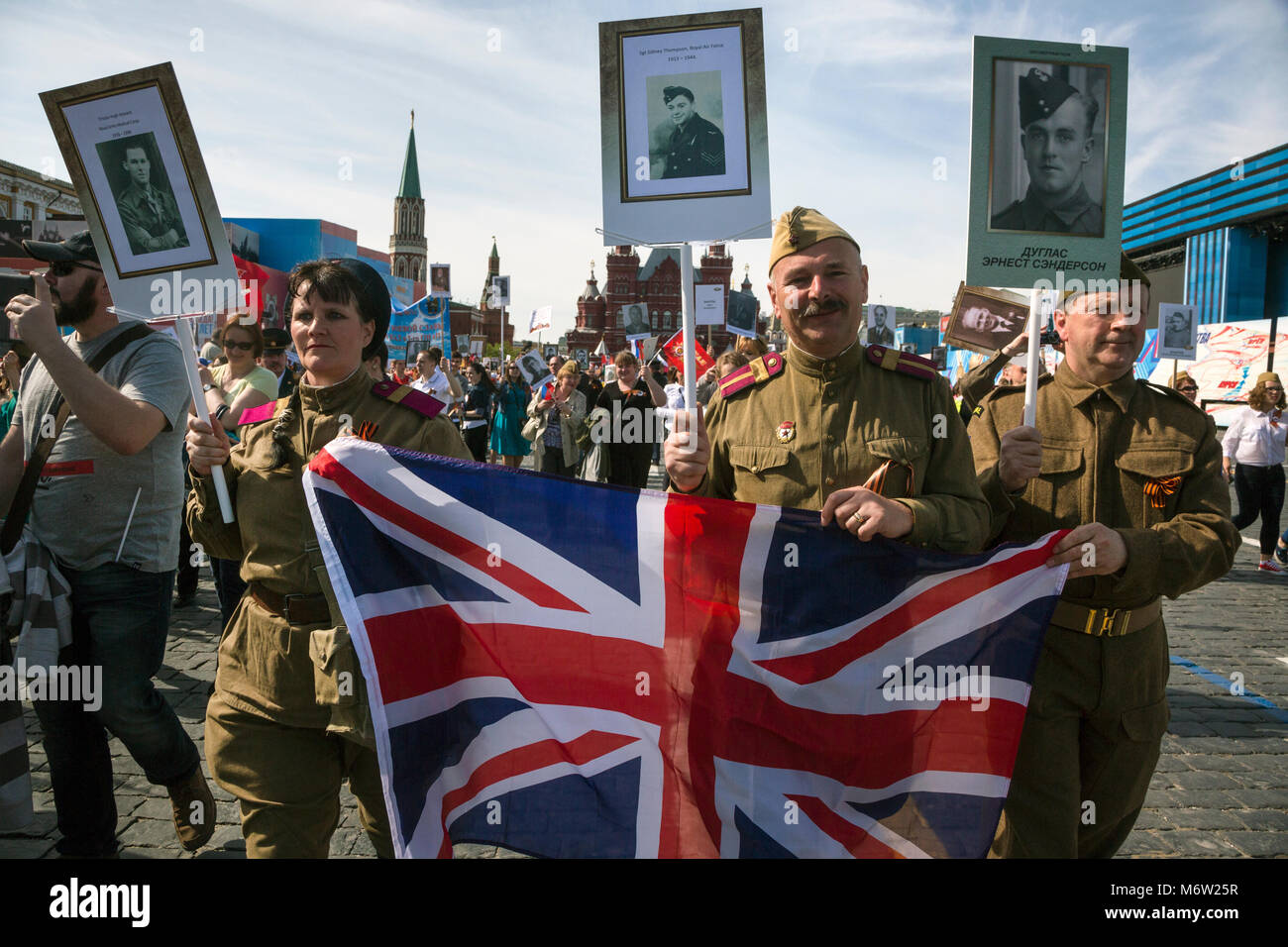 Menschen mit Porträts von Weltkrieg Soldaten und in Großbritannien Flagge Spaziergang auf dem Roten Platz während der Unsterblichen Regiment März in Moskau, Russland Stockfoto