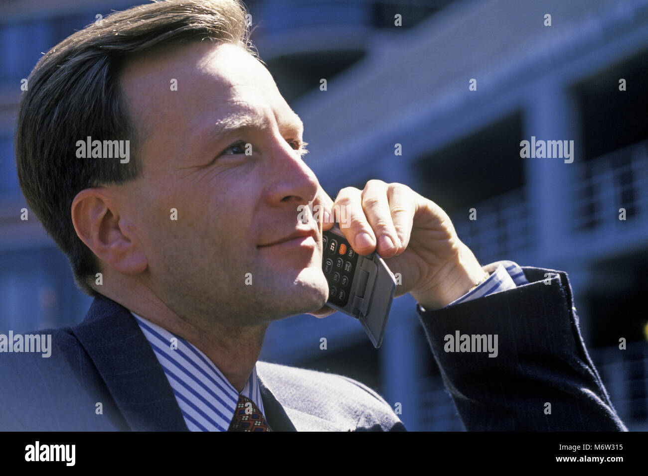 1995 historische KAUKASISCHEN GESCHÄFTSMANN MIT MOBILTELEFON TELEFON (© MOTOROLA CORP 1995) IM FREIEN Stockfoto