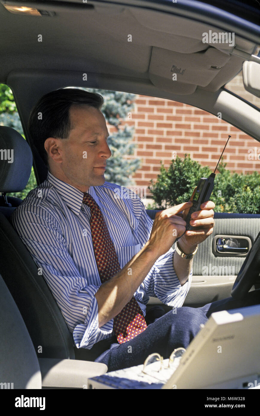 1995 historische KAUKASISCHEN BUSINESS SALES MANN MIT HANDY (© MOTOROLA CORP 1995) IN MOBILEN AUTOMOBIL BÜRO Stockfoto