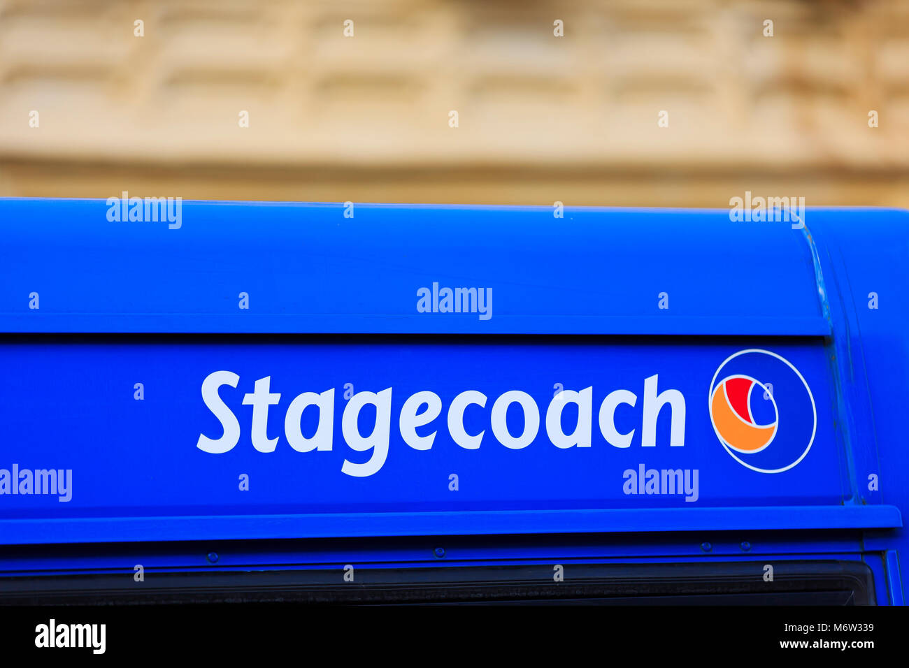Die Postkutsche Name & Logo auf einem blauen Bus in Cirencester, Glocs. Stockfoto