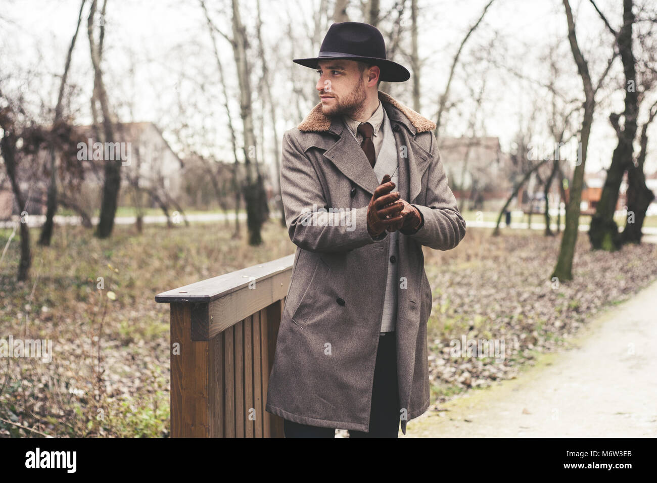Schönen eleganten Mann im Park tragen Anzug und Mantel. Stockfoto