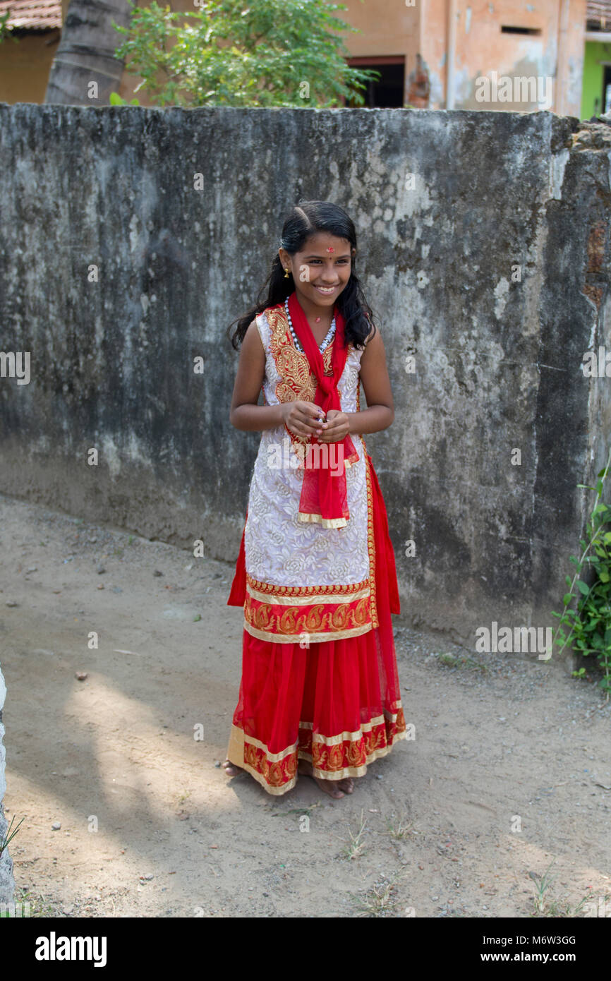 Lächelndes junges indisches Mädchen in rot-weißem und goldenem traditionellen Kleid in Kerala, Indien Stockfoto