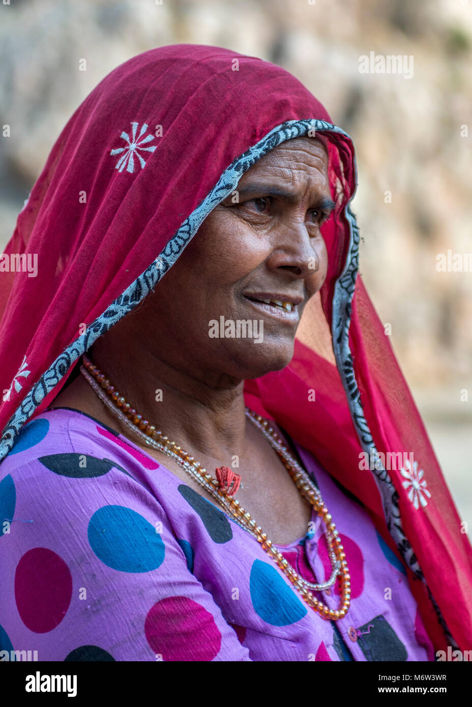 Porträt einer älteren indischen Frau mit einem bunten roten, lila und blauen Sari (Saree) in Samode, Rajasthan, Indien Stockfoto