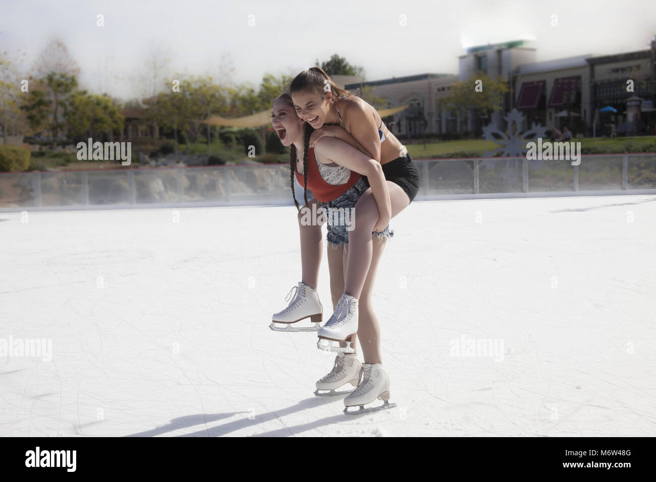 Zwei jugendlich Mädchen Freunde weg vermasseln auf einer Eisbahn in Südkalifornien Stockfoto
