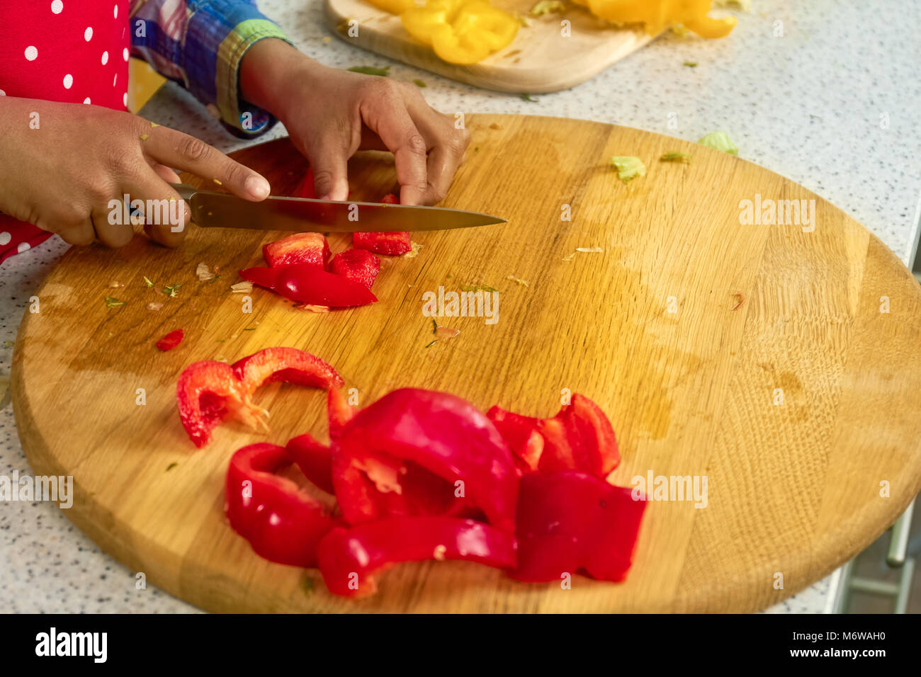 Die Hände der Jungen schneiden Paprika. Stockfoto