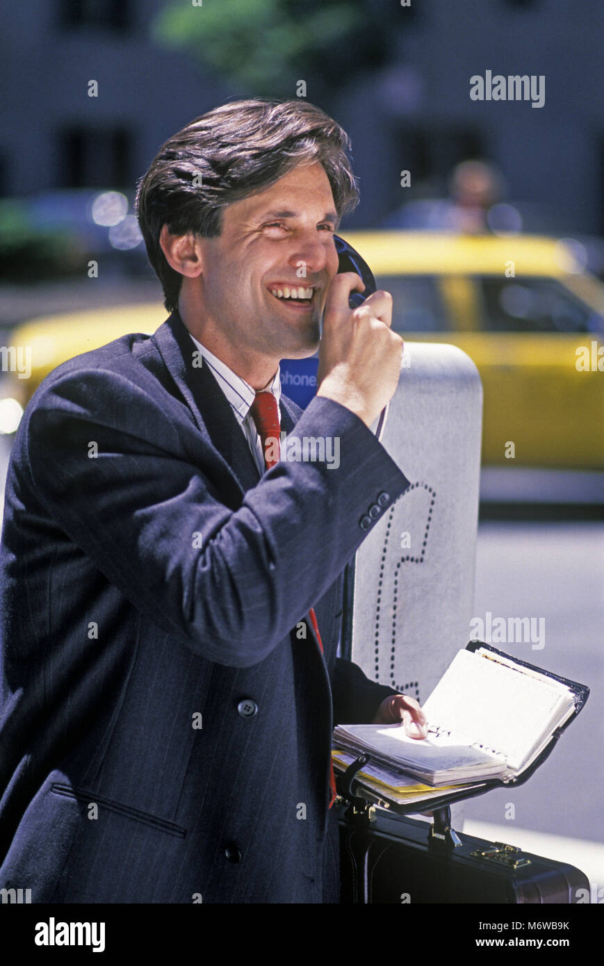 1994 historische KAUKASISCHEN GESCHÄFTSMANN AN ÖFFENTLICHEN MÜNZTELEFON (© ATT 1994) HOLDING FILOFAX PAPIER ORGANIZER (© LETTS FILOFAX GROUP 1994) Stockfoto