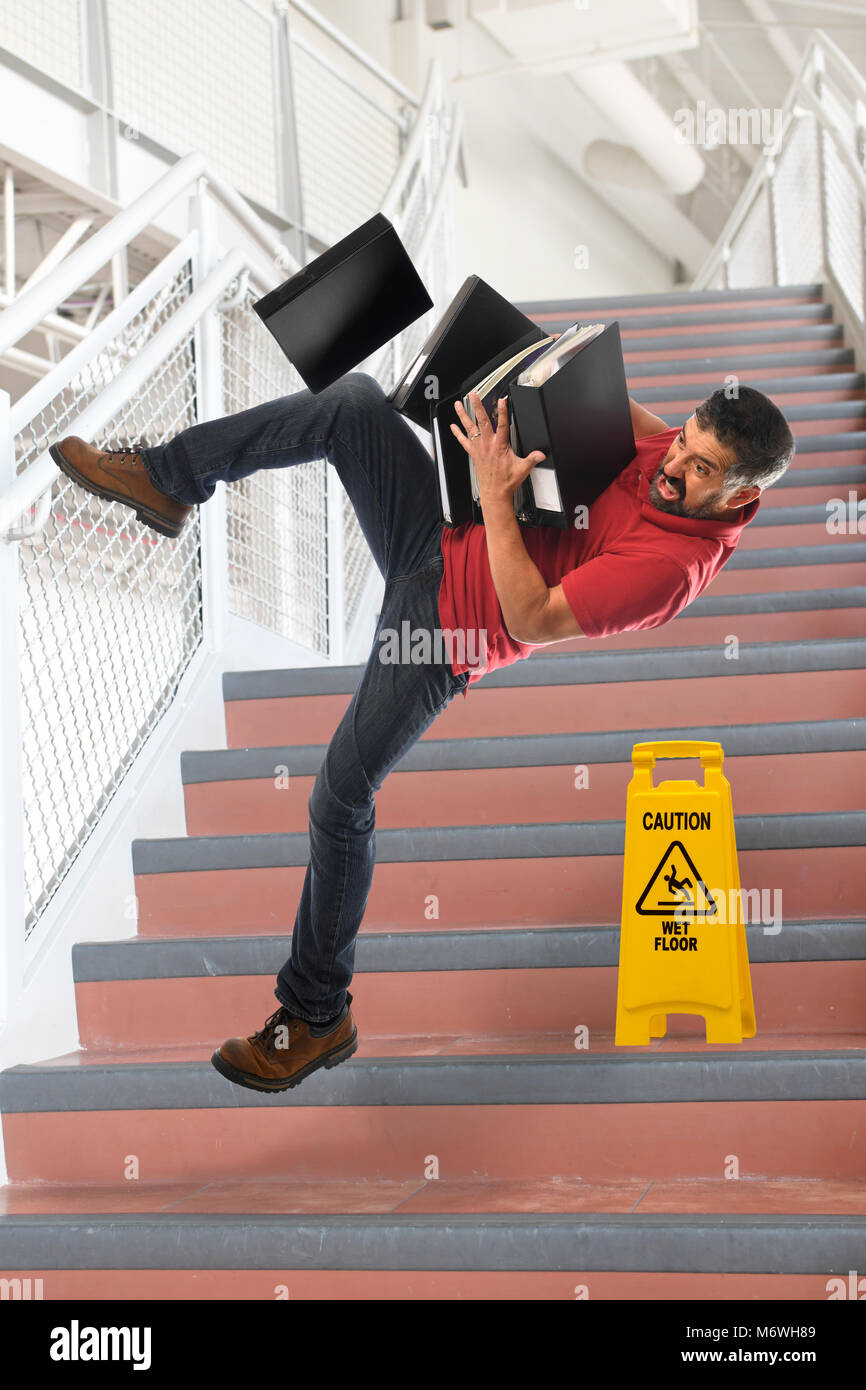 Hispano-Amerikaner Geschäftsmann Sturz auf Treppe während des Tragens Ordner Stockfoto