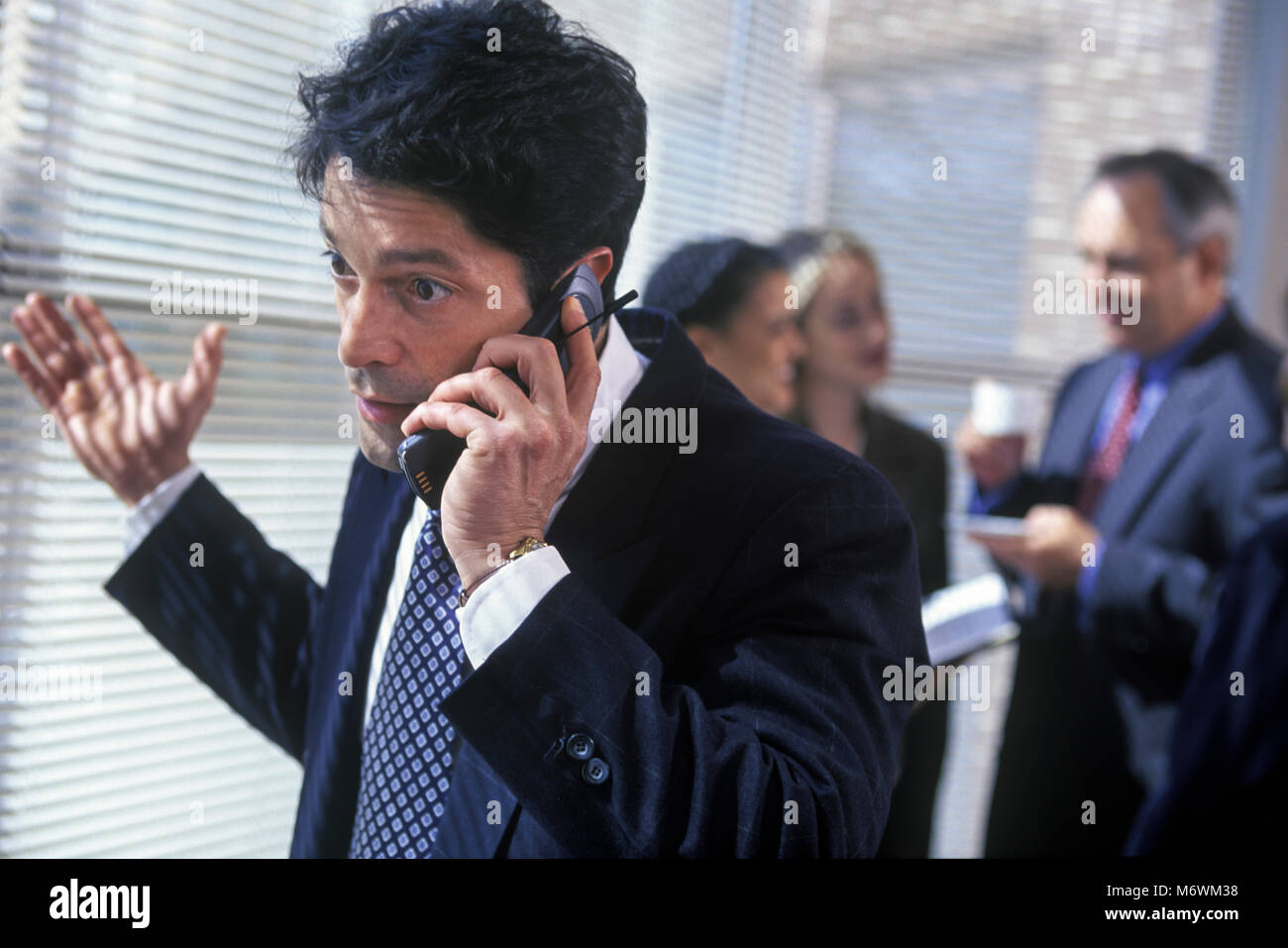 1998 historische KAUKASISCHEN GESCHÄFTSMANN TAGUNG IM KONFERENZRAUM HOLDING MOBILE MOBILTELEFON Stockfoto