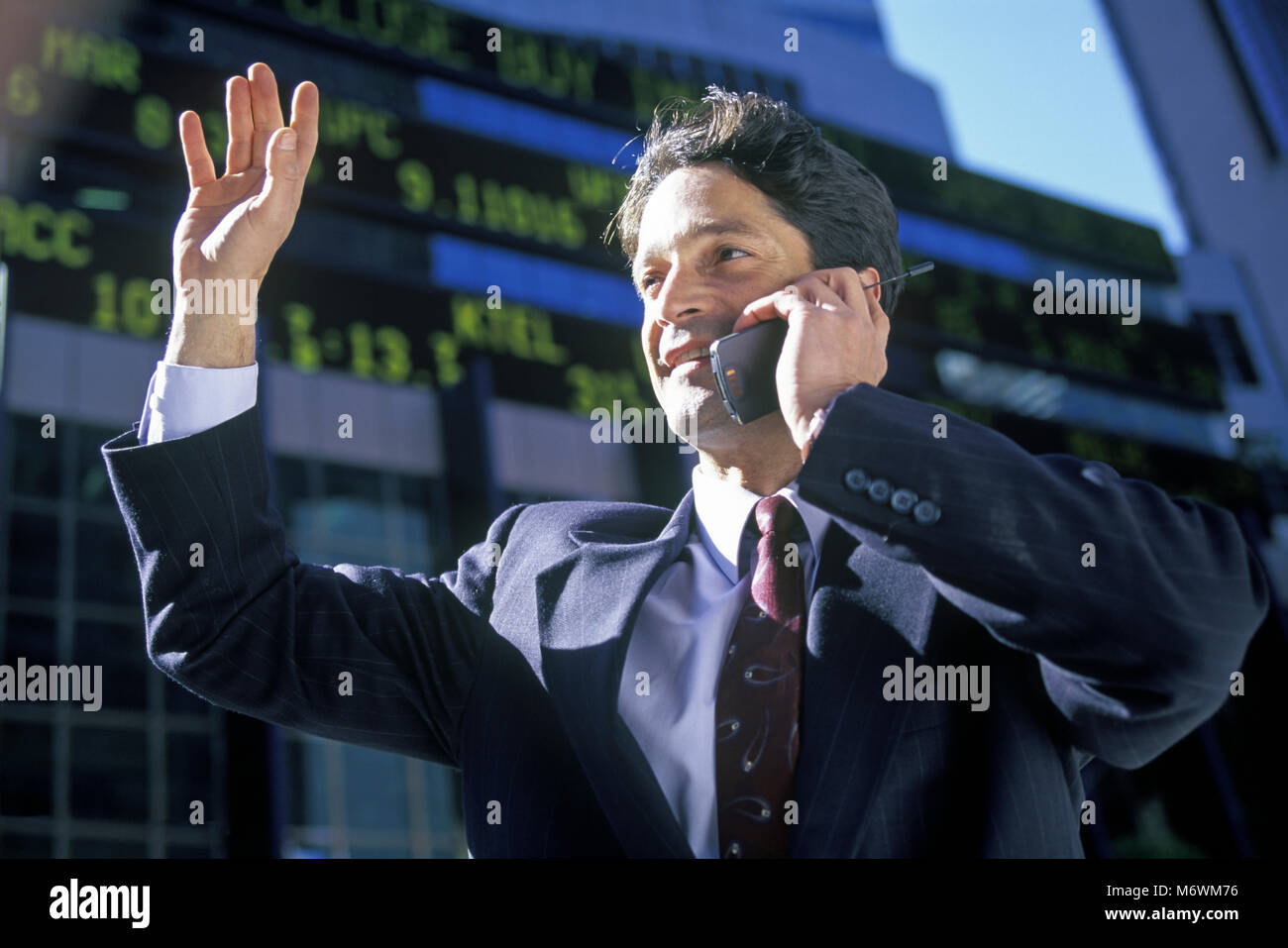 1998 historische KAUKASISCHEN GESCHÄFTSMANN MIT MOBILTELEFON TELEFON AM BÖRSENKURS TICKER ANZEIGE Stockfoto