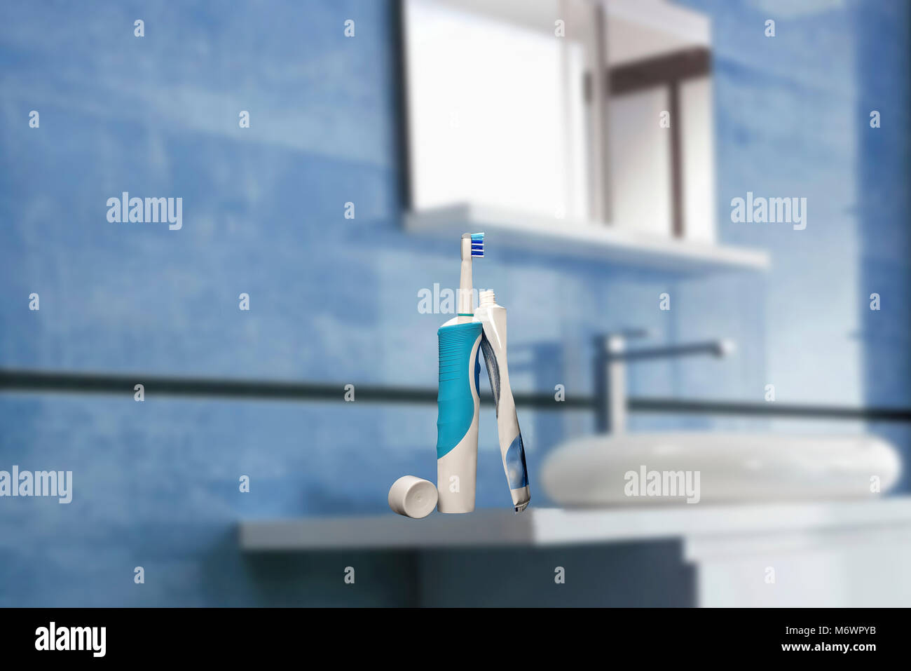 Elektrische Zahnbürste mit Zahnpasta in einem blauen Badezimmer Stockfoto