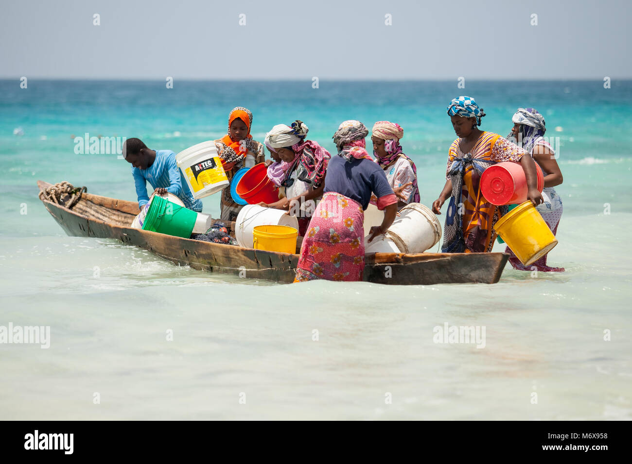Stone Town, die Insel Sansibar, Tansania, 28.05.2015. Frauen sammeln kleine Fische in einem Boot an der Küste von Stone Town, die Insel Sansibar, Tansania. Stockfoto