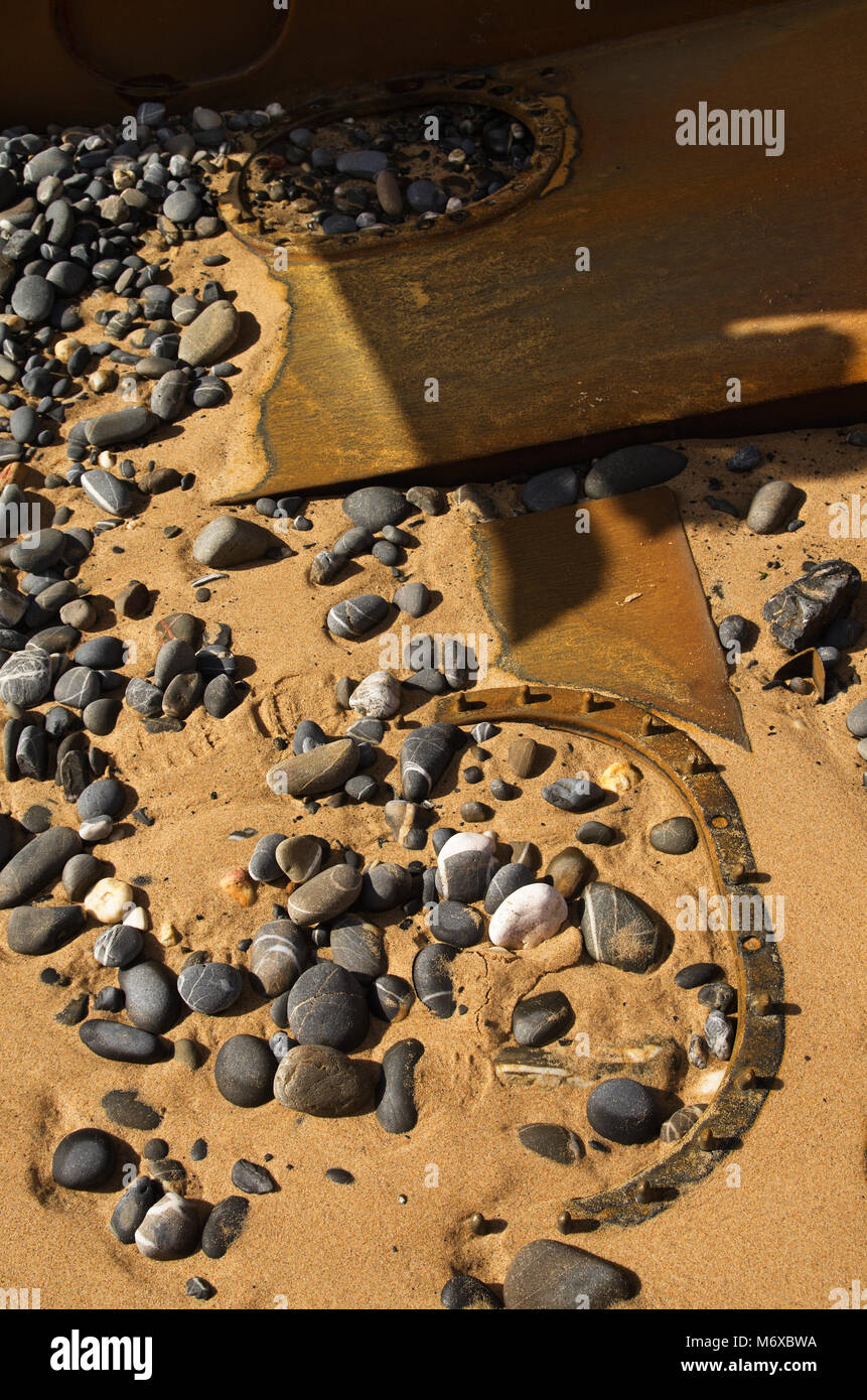 Alte havarierten Boot Luken und Rumpf Teile in der Strand Sand zwischen den Steinen, Peebles und Rumpf Teile begraben. Stockfoto