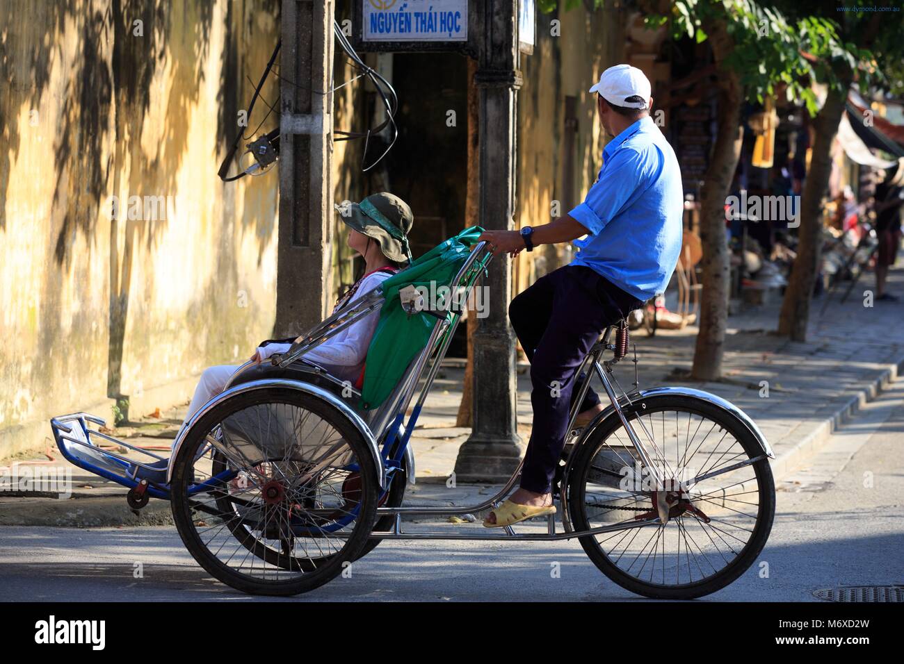 Dreirad Rikschas sind ein beliebter Weg für Touristen durch die Straßen der Altstadt von Hoi An, Vietnam Stockfoto