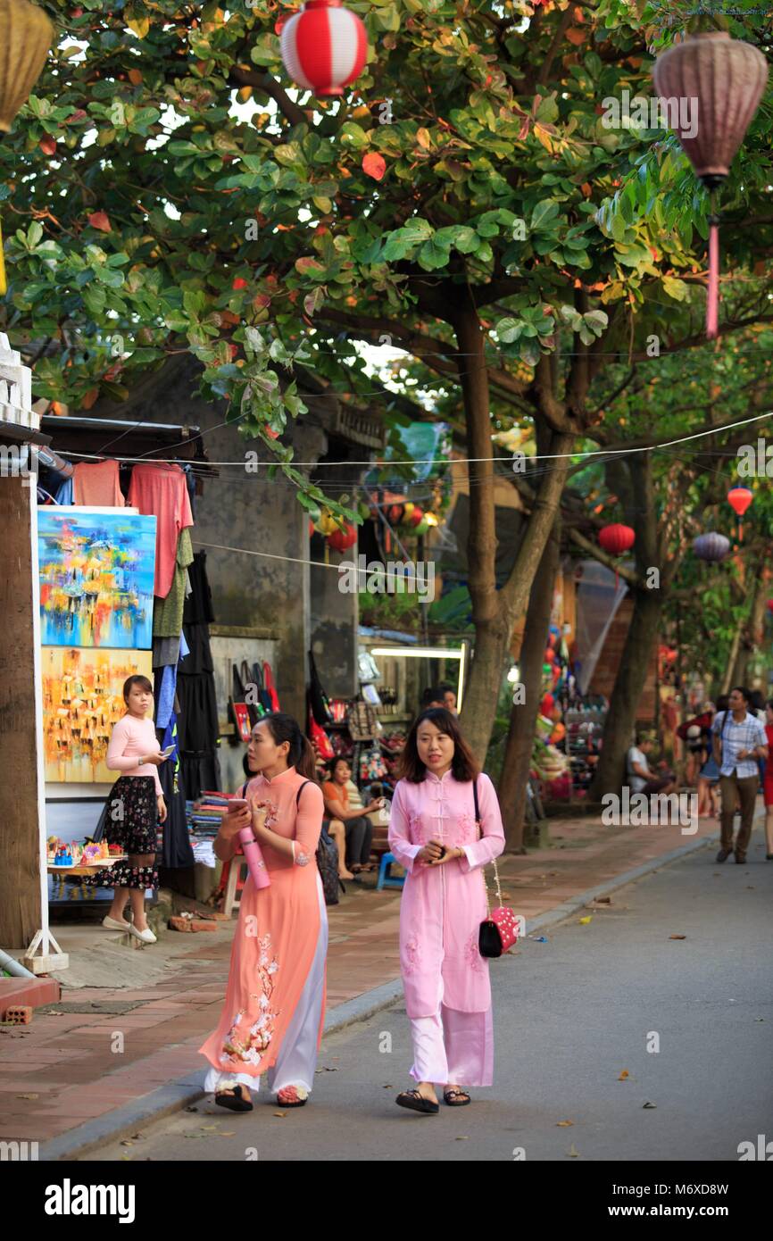 Zwei Frauen in traditionellen Ao Dai Kleidung shopping auf den Straßen von Hoi An, Vietnam Stockfoto