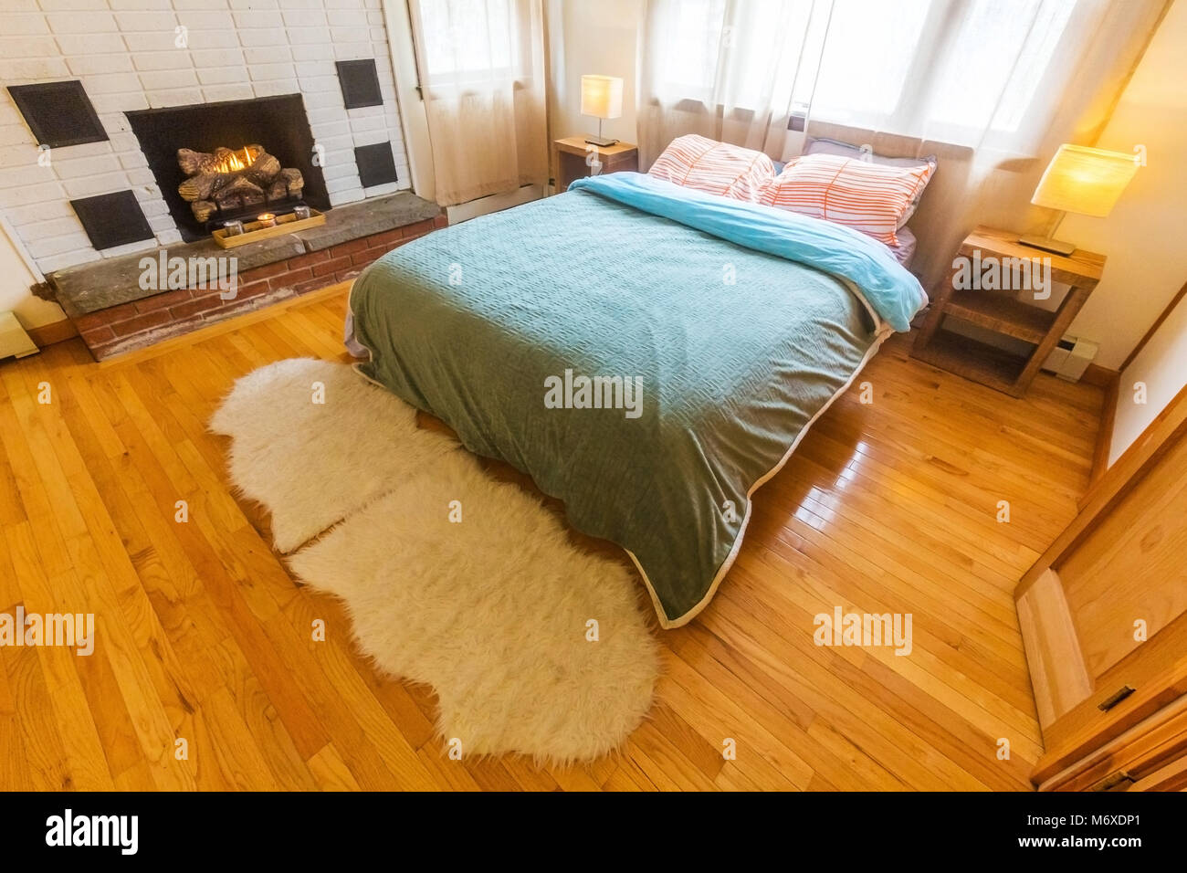 Schlafzimmer mit grossem Bett und einem Kamin am Tag Licht Stockfoto