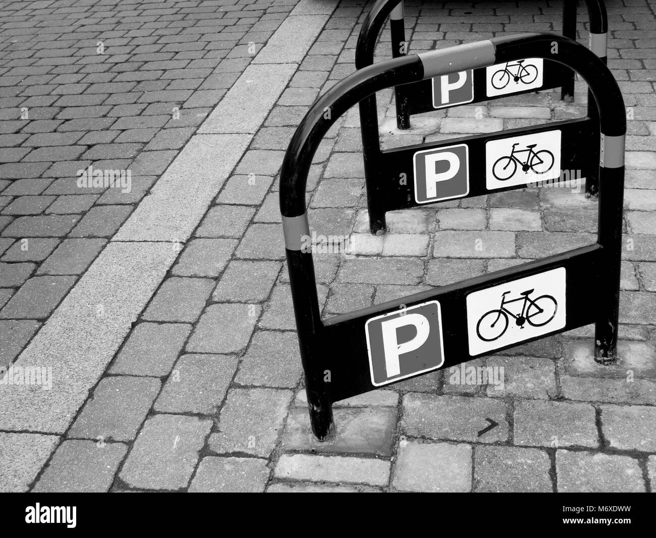 Metall öffentlichen Parkplatz für Fahrräder steht auf gepflasterten Bereich der Haupteinkaufsstraße Stockfoto