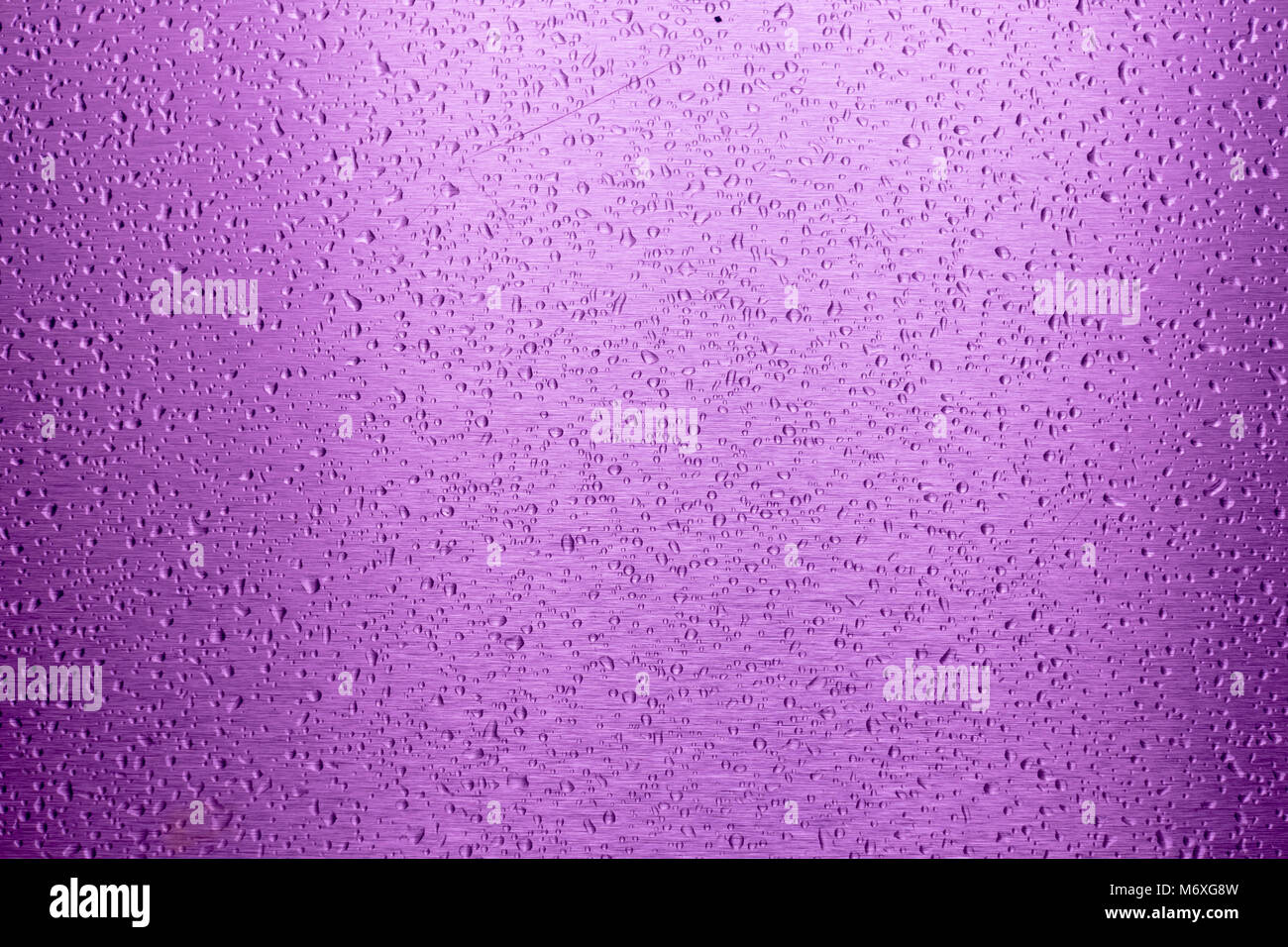 Wassertropfen auf lila Metalloberfläche als Hintergrund Stockfoto