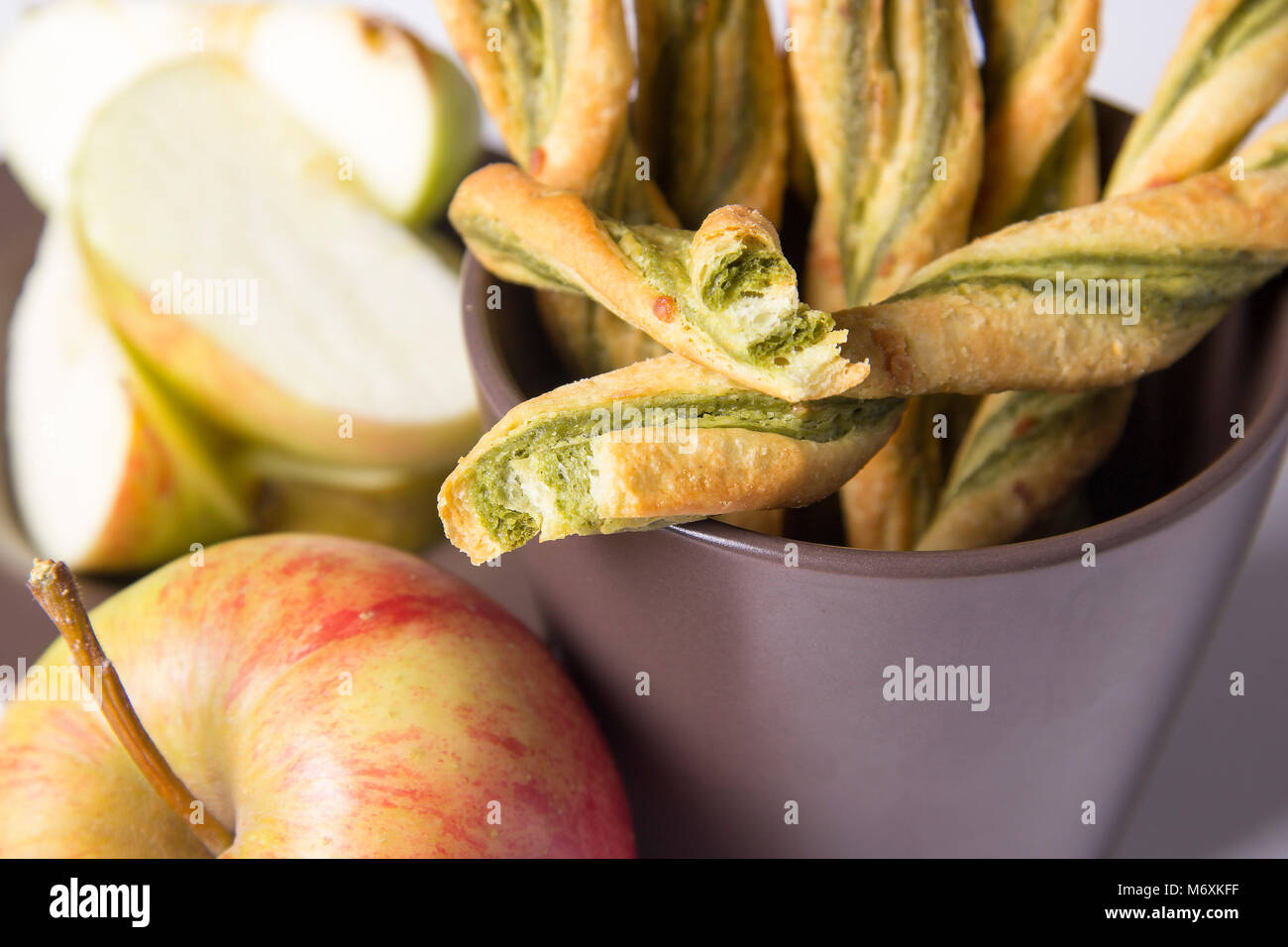 Käse und Pesto Wendungen eine Schale mit Äpfeln Stockfoto