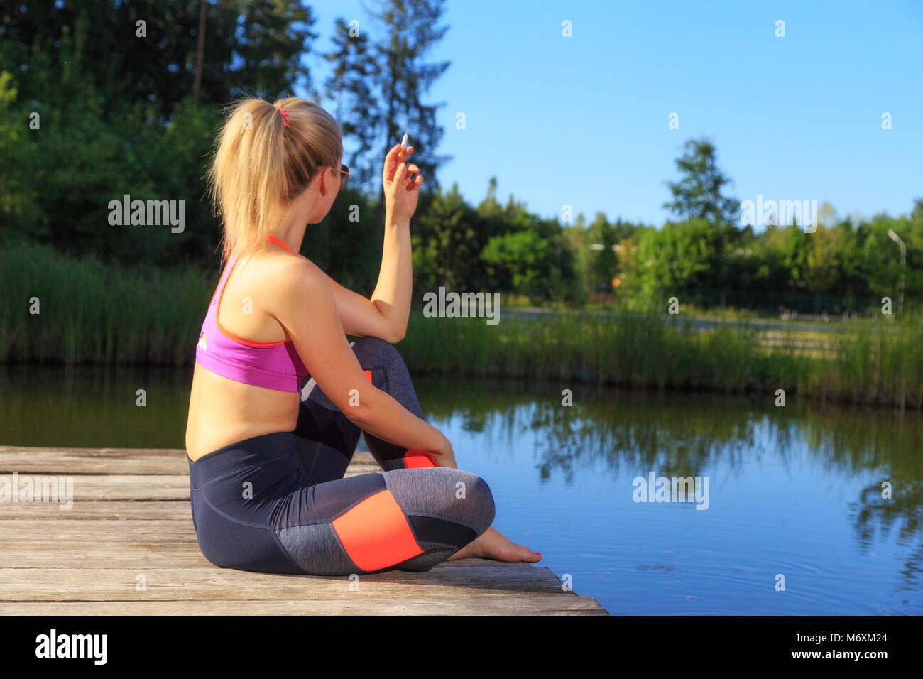 Eine sportliche Frau nimmt eine Zigarettenpause Stockfoto