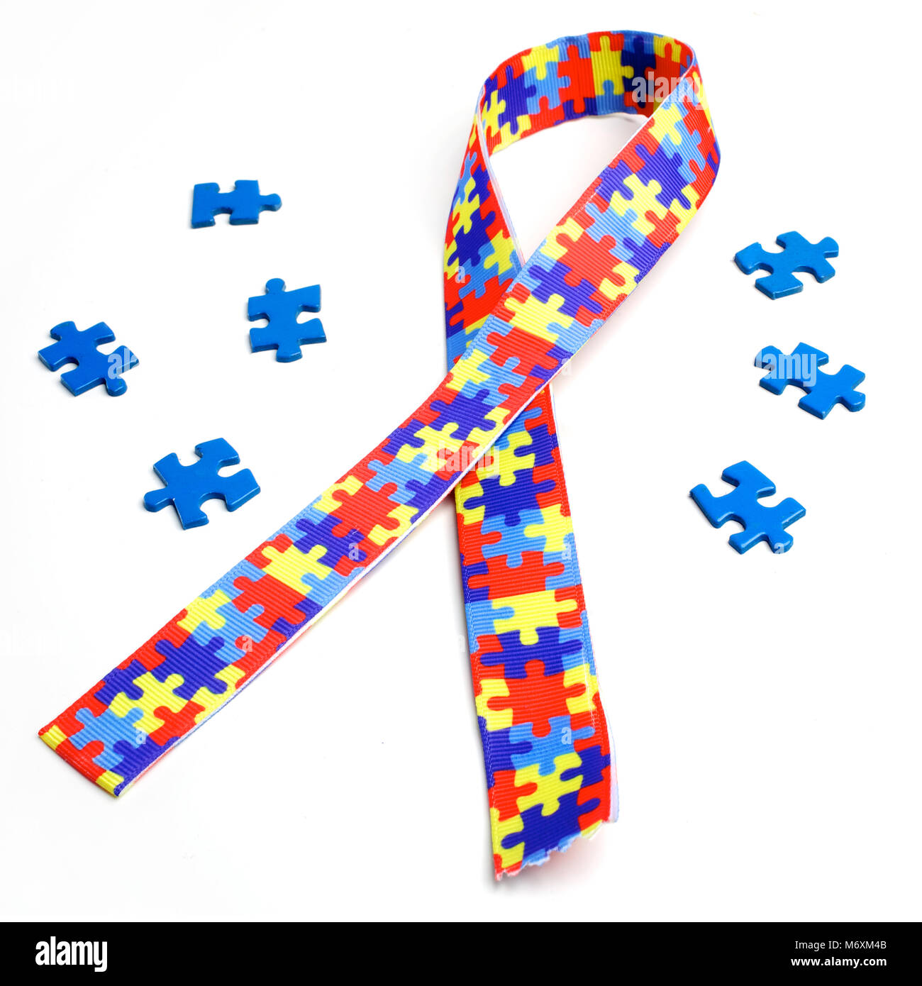 World Autism Bewußtsein und stolz Tag mit Puzzle Muster Band auf weißem Hintergrund Stockfoto