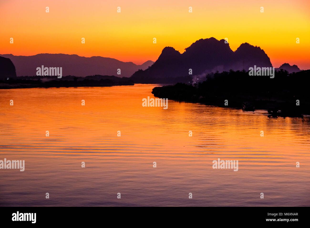 Sonnenuntergang über den Bergen auf der anderen Seite des Saluen Thanlyin Fluss Stockfoto