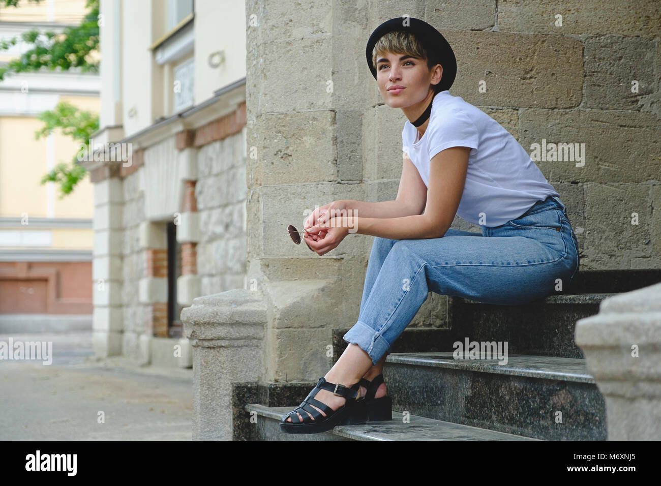 Schöne junge Hipster Frau posiert auf Treppen Stockfoto