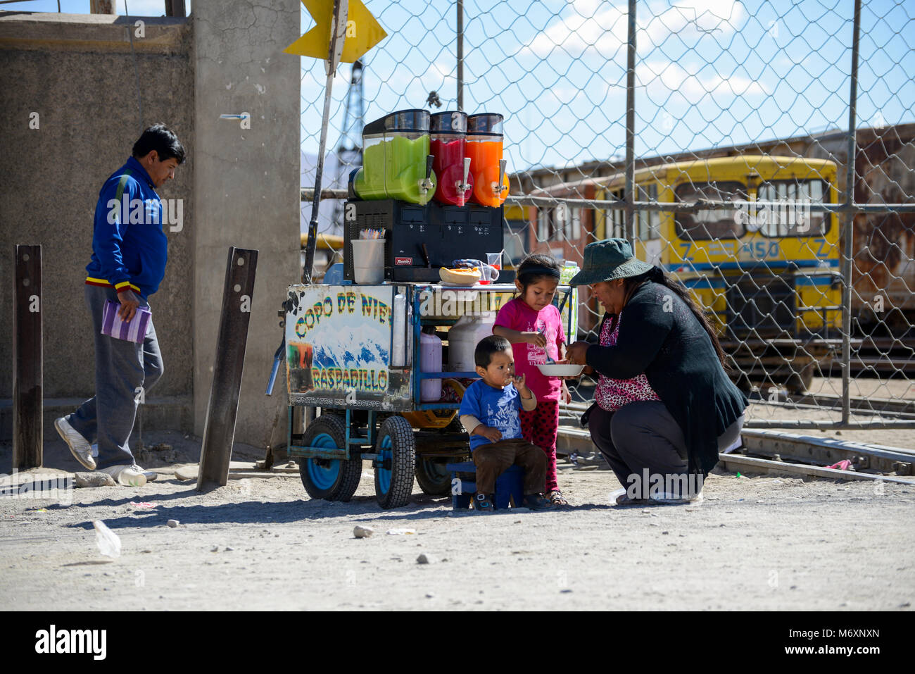 Bolivianischen streetlife Szene einer Dame bietet Kindern ein Eis essen im Stehen Stockfoto