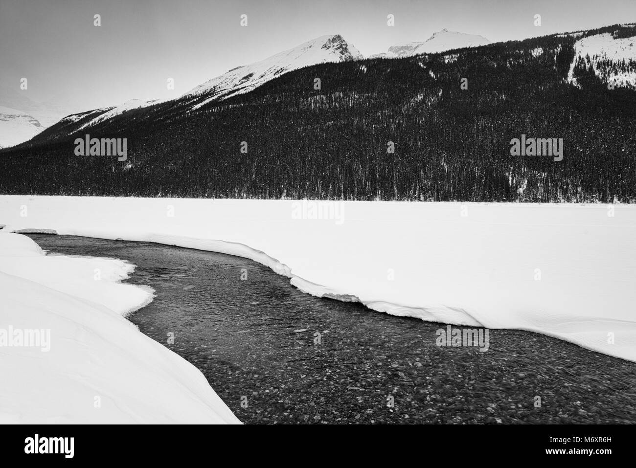 Verschneite Winterlandschaft mit fließenden Fluss und Berge in den kanadischen Rockies, Jasper National Park Stockfoto