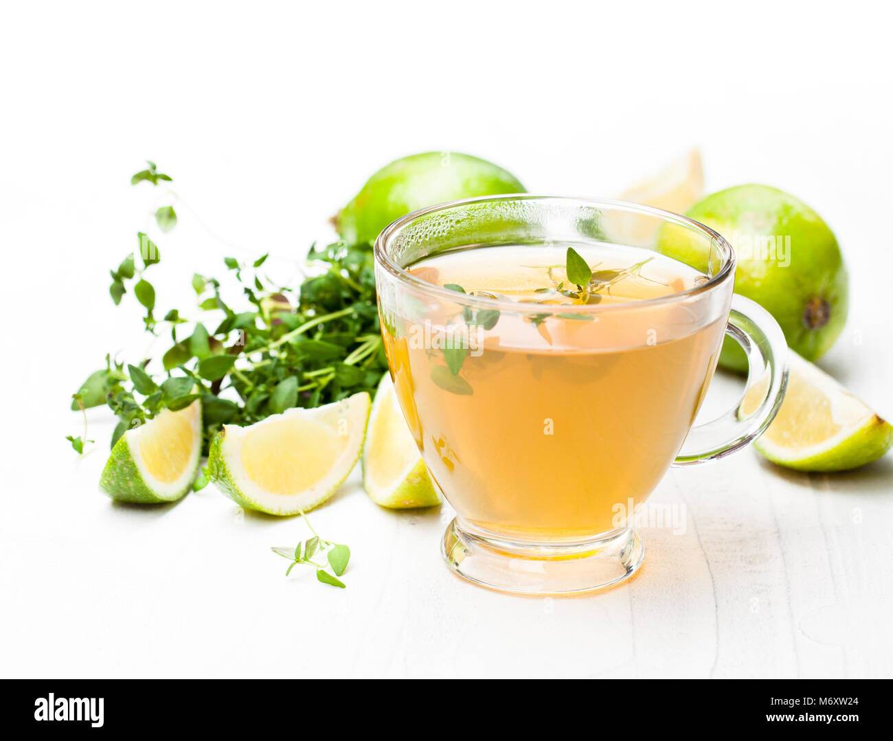 Grüner Tee mit Thymian und Kalk auf weißem Hintergrund Stockfoto
