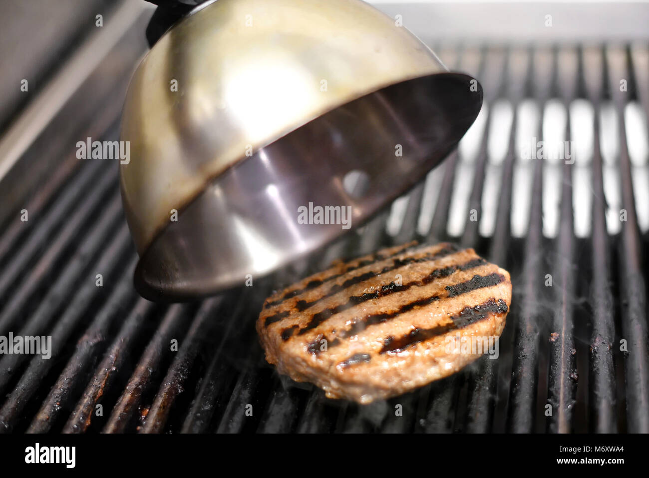 Kochen ein Rind hamburger Patty auf einem elektrischen Grill in einem Fast-Food-Restaurant in der Nähe zu sehen, auf dem Fleisch Stockfoto