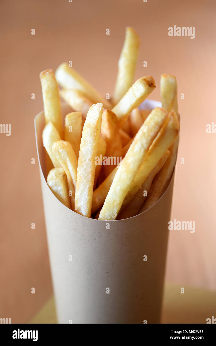 Teil der Knusprig frittierte Goldene Kartoffel Chips oder Pommes frites serviert in einem Container Stockfoto