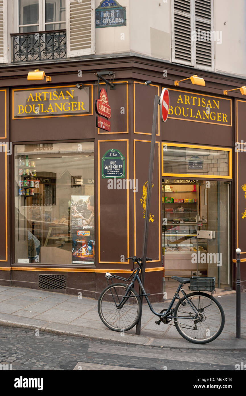 PARIS, FRANKREICH - 06. MAI 2011: Fahrradfahren vor der hübschen handwerklichen Boulangerie Bäckerei in der Rue St Gilles im Viertel Le Marais Stockfoto