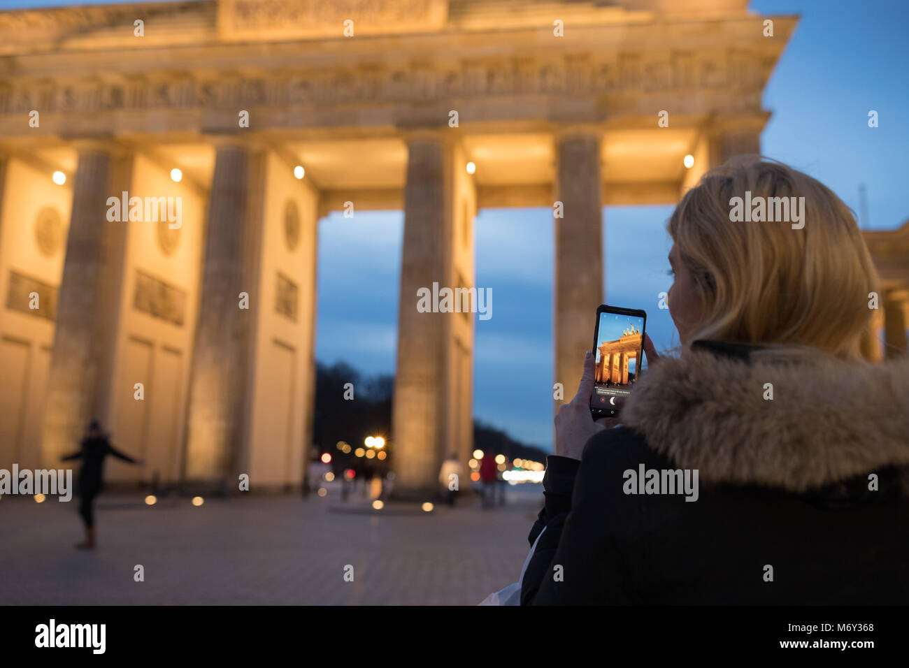 Ein Tourist, der ein Bild auf Ihrem Handy am Brandenburger Tor, Mitte, Berlin, Deutschland Stockfoto