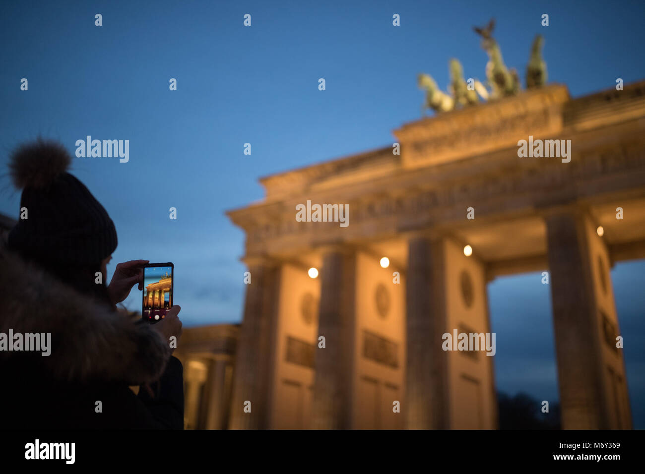Ein Tourist, der ein Bild auf Ihrem Handy am Brandenburger Tor, Mitte, Berlin, Deutschland Stockfoto
