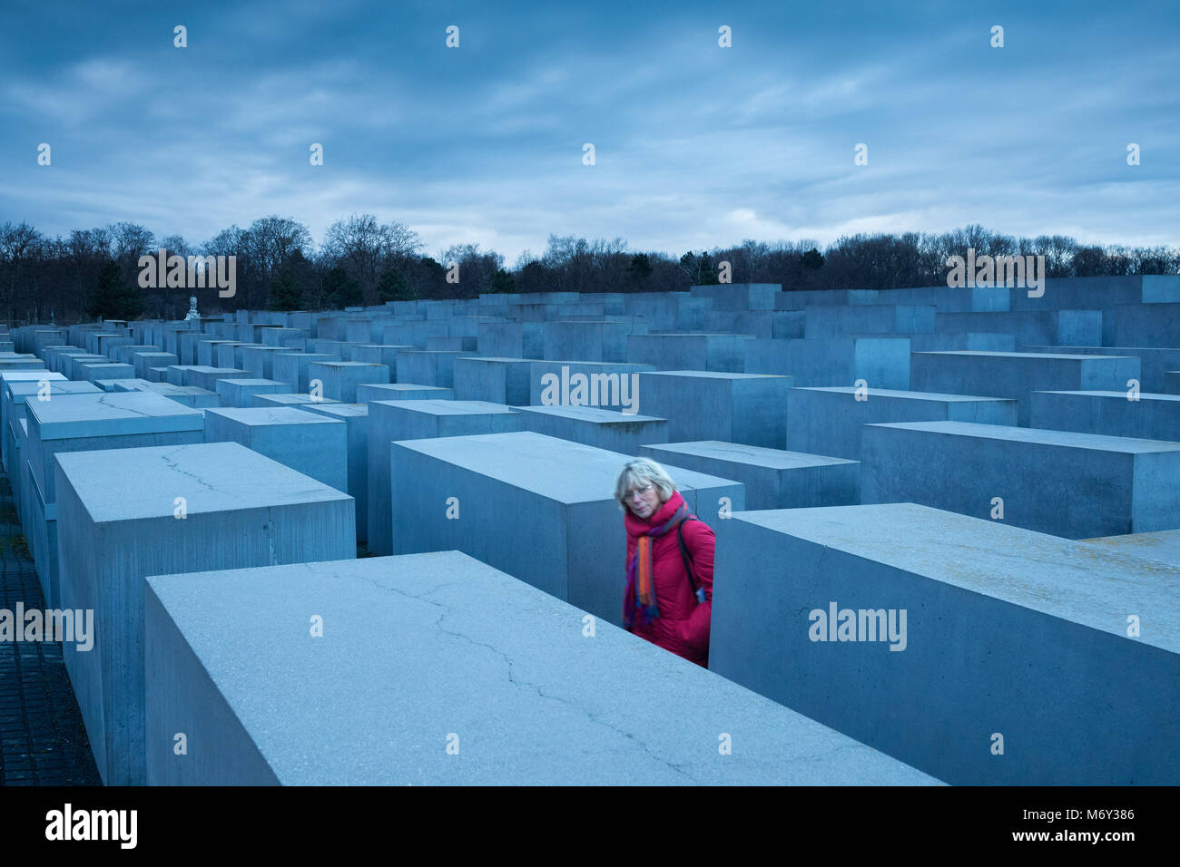 Eine Dame in rot in unter den Holocaust Memorial, Mitte, Berlin, Deutschland Stockfoto