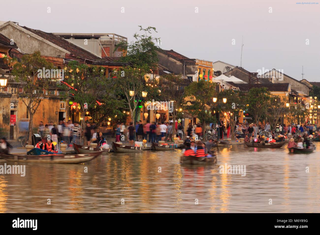 Die Dämmerung fällt auf Bach Dang Street Touristen zu Boote auf dem Thu Bon Fluss nehmen, um die Aussicht zu genießen. Stockfoto