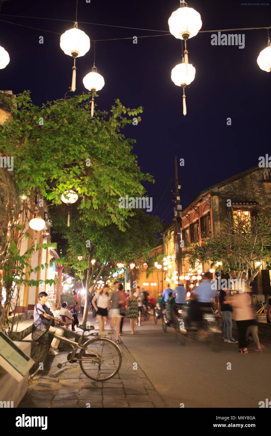 Touristen mischen sich mit Einheimischen unter bunten Laternen in der Altstadt von Hoi An, Vietnam Stockfoto