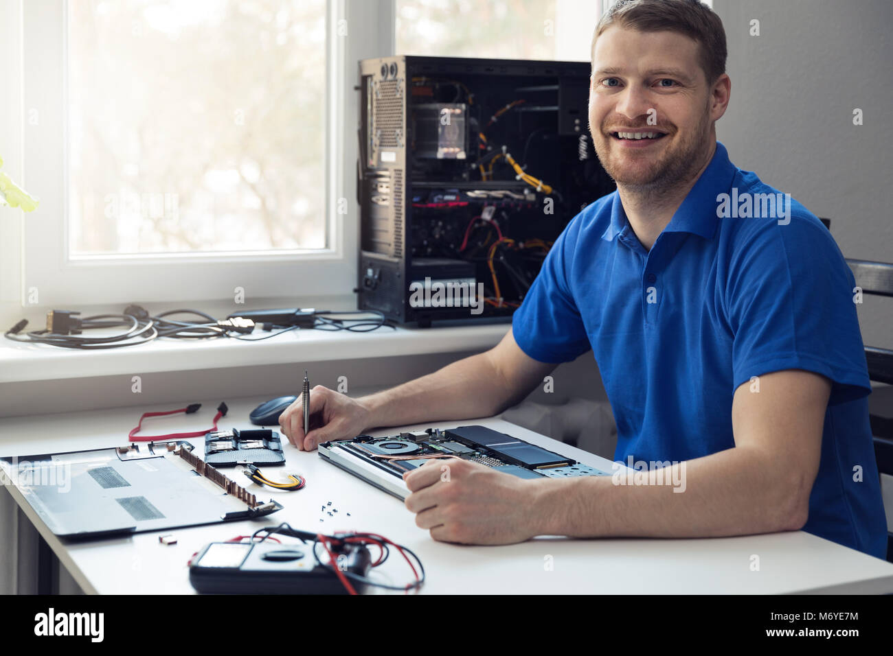 Lächelnden jungen Elektronik Techniker bei der Arbeit Stockfoto