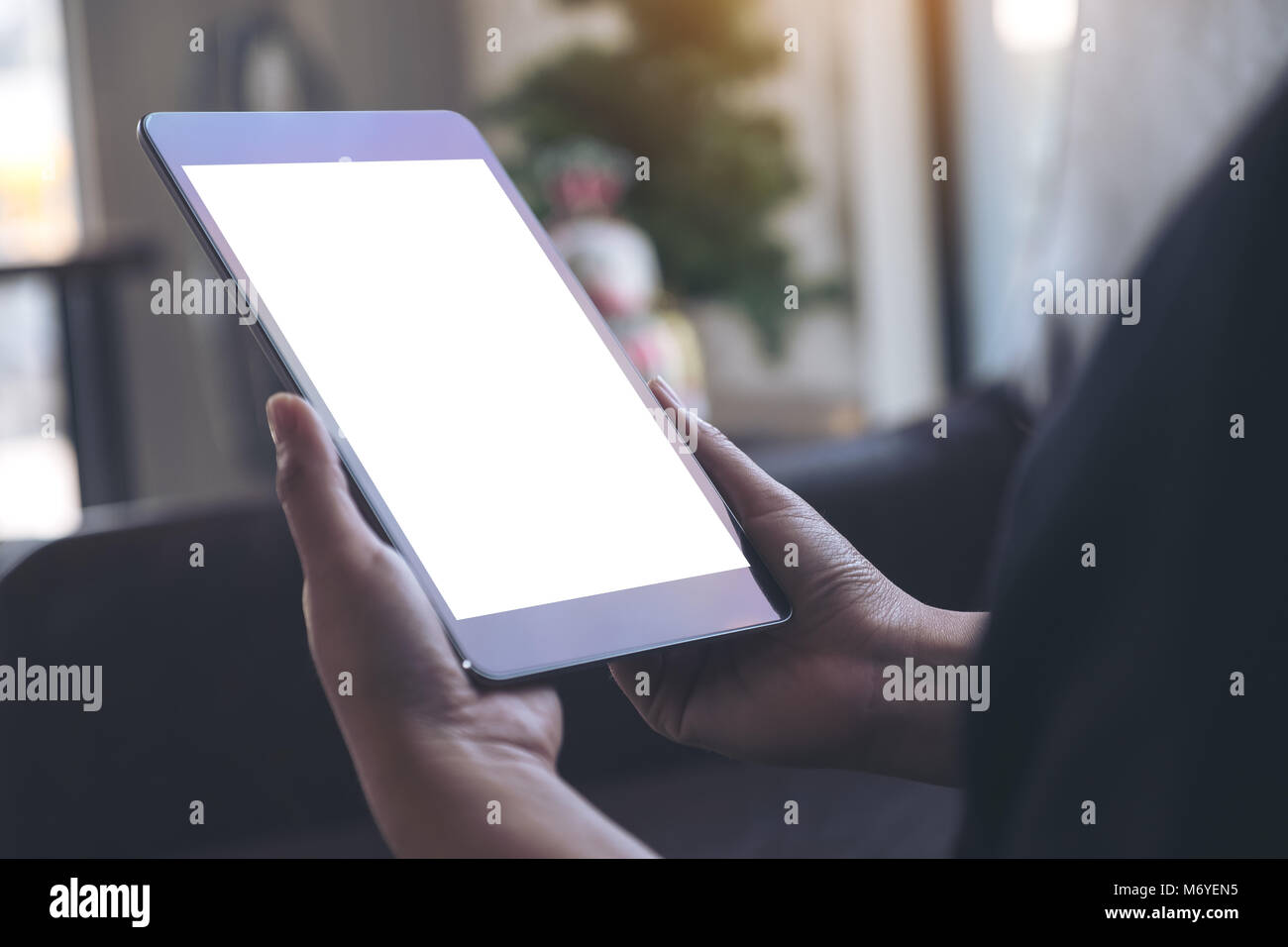 Mockup Bild der Hände halten Schwarze Tablette mit leeren weißen Bildschirm. Stockfoto